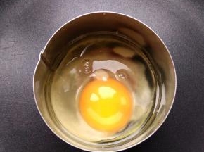 热锅热油，讲一个鸡蛋打进圆形模具中，小火加热。也可以提前将鸡蛋打散，蛋液中混少许盐，再倒入模具中煎。