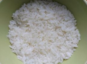 取适量米饭，在一个小碗里压实