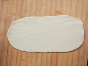 将面团分成两半，其中一半擀成长条薄片