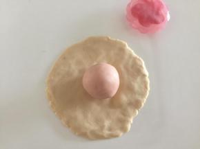 取20克牛奶桃山皮，压成薄片，将做好的内陷放在中间