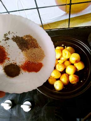 小土豆煎熟之后关火，把准备好的除了葱花之外的配料一起倒进锅中。