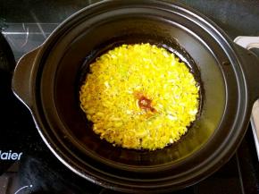 浅煲中倒油，油热后加入葱花和花椒粉爆香。这里我要强调一下，只有可以干烧的锅才可以这样操作，普通的砂锅是不可以直接在锅里爆香炝锅的。