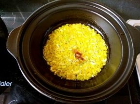 浅煲中倒油，油热后加入葱花和花椒粉爆香。这里我要强调一下，只有可以干烧的锅才可以这样操作，普通的砂锅是不可以直接在锅里爆香炝锅的。