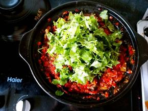 待锅中的茄子条煮至软烂就可以关火了，把香菜段放进去。