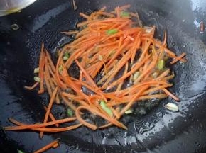 再把胡萝卜丝下入锅中翻炒，此时如果有洋葱可以随胡萝卜一起入锅。