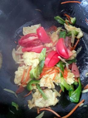 接下来再把西红柿，鸡蛋等一起加入锅中，简单翻炒几下。