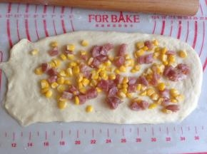 将玉米香肠馅分成三份，将馅料放在上面