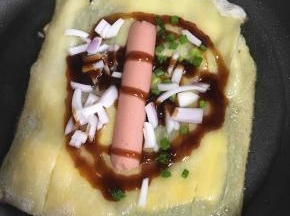 放上火腿肠，洋葱块，香菜碎，你还可以根据自己喜欢放点其他食材
