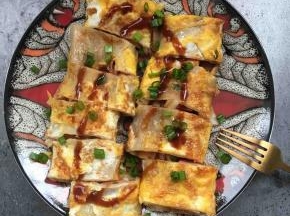 表面再淋上一点酱汁，撒一些葱花
我们老家的小吃摊，还要再放一些白糖和错，这个根据自己的口味调吧