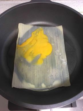 放入一个鸡蛋，用铲子拍开，均匀的涂抹在冷面上
