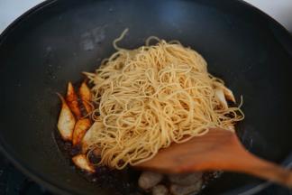 放入最开始备好的竹升面，继续翻炒均匀