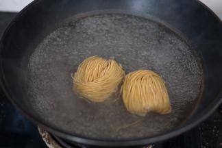 锅内烧开水，下面饼煮至8分熟