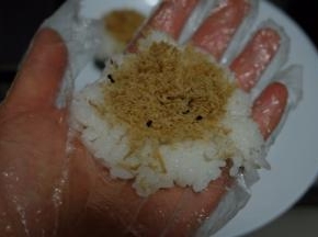 戴上一次性手套，抓一小块米饭在手里按扁，放上一点肉松，这个肉松是我自己做的，想要看做法的可以看我昨天发的贴子；