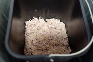 敲打后的肉肉用手抓散，很容易就散开了，然后放进面包机内桶里，倒进一大勺的生抽酱油和一小勺的白砂糖，用面包机的“果酱”功能进行制作。（如果有肉松功能就直接用肉松功能，我这个面包机没有，所以用的果酱功能。如果没有面包机，也可以用炒锅小火翻炒，但会很费时间，累胳膊）