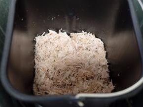 敲打后的肉肉用手抓散，很容易就散开了，然后放进面包机内桶里，倒进一大勺的生抽酱油和一小勺的白砂糖，用面包机的“果酱”功能进行制作。（如果有肉松功能就直接用肉松功能，我这个面包机没有，所以用的果酱功能。如果没有面包机，也可以用炒锅小火翻炒，但会很费时间，累胳膊）