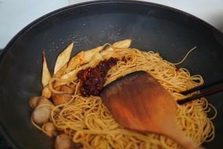 老干妈放入锅内，继续翻炒