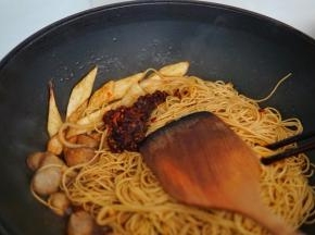 老干妈放入锅内，继续翻炒