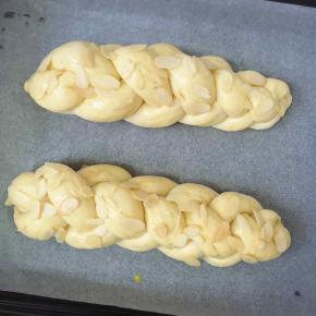 发酵好的面团明显发胖，此时面包表皮刷上蛋液，撒上杏仁片