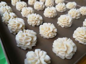 在烤盘上挤出网红曲奇花的形状，这种形状的花型要手持裱花袋垂直烤盘，手一提一压左右轻微摆动的方式垂直挤出，要一气呵成。