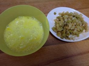 把鸡蛋打成蛋液，榨菜切碎；