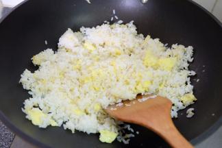 把剩米饭倒进去，用铲子边炒边按压，把米饭里结团的小块都按散，使每粒米都能够感觉到锅的温度；