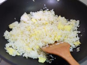 把剩米饭倒进去，用铲子边炒边按压，把米饭里结团的小块都按散，使每粒米都能够感觉到锅的温度；
