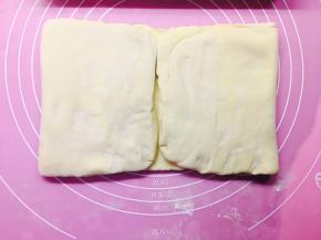 20分钟后，面团从冰箱取出，再次擀成长方形。这次，两边对面饼中心线位置对折。