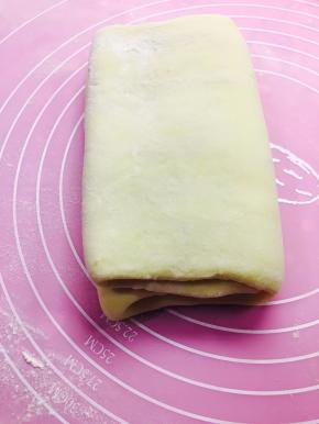 然后按整体面饼中间位置折叠。完成第一次折叠。放入冰箱冷冻20分钟。