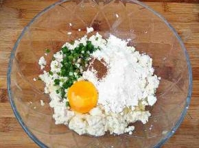 豆腐捏碎，加入盐，鸡蛋，葱花，面粉，五香粉。