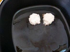 取一团放入锅中，用手微微压扁成饼状。