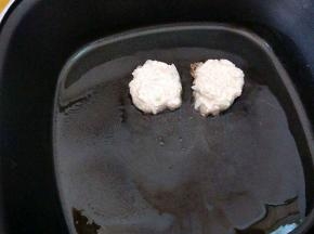 取一团放入锅中，用手微微压扁成饼状。