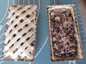 把做好的莲蓉红豆馅放入，我喜欢馅多的，放的满满的馅。然后把多余的酥皮切成条，装饰表面