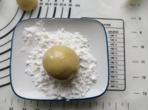 把月饼坯扔进玉米淀粉中滚一下。