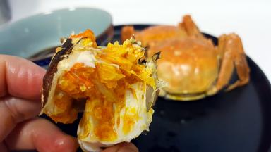 将蟹身从中间掰开，你会看到一个扁的片是蟹心，这个也不可以吃。还有就是蟹盖上面，有一个像塑料袋一样的东西，这个是蟹胃也是不能吃的。