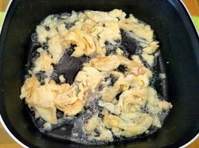 热锅热油，下打散的鸡蛋炒成型。