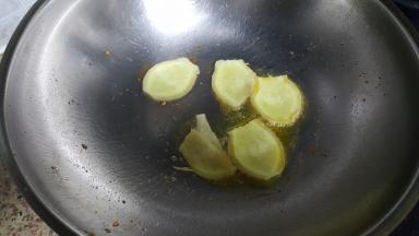 15.倒出多余的油，留少许在锅内，放入姜片炒出香味。