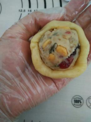 用虎口慢慢往上推，轻轻转动直到全部包住馅为止