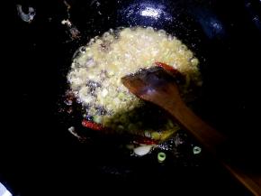 把葱姜蒜，花椒粉大料粒和红辣椒倒入锅中爆香。