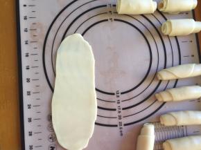 将酥皮再次擀成牛舌状，从下往上卷起