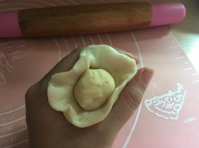 包入油酥，放在虎口处轻轻一推就可以包好
