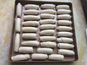 然后将卷好的油酥皮放入烤盘里盖上保鲜膜静置20分钟