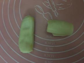 继续取卷好的油皮，像左边那样按扁，再用擀面杖轻轻擀成长舌形，从上而下卷起（右边）