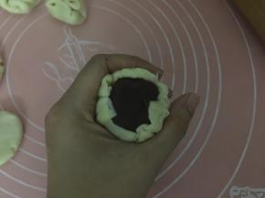 包入馅料，放于虎口处轻轻往上推