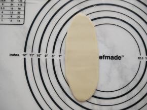 取一个包好的面团擀成牛舌状。