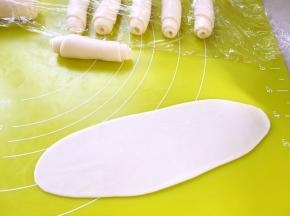 将松弛好的面团擀成长条，卷起来，盖保鲜膜松弛15分钟