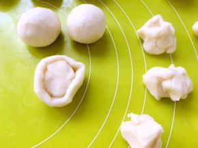 取一份水油皮材料，用手掌压扁，包裹上油酥皮材料，收好收口，之后盖保鲜膜松弛10分钟