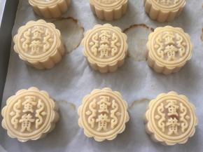 装入50克月饼模具，压出自己喜欢的花型，之后喷点水，静置10分钟，烤箱预热180度，打一颗蛋黄，带一点点蛋白，一起打散，用羊毛刷沾上蛋黄液，之后在杯壁上刮掉多余的蛋液，薄薄的刷一层在月饼表层