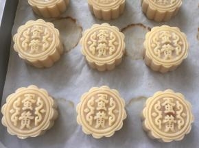 装入50克月饼模具，压出自己喜欢的花型，之后喷点水，静置10分钟，烤箱预热180度，打一颗蛋黄，带一点点蛋白，一起打散，用羊毛刷沾上蛋黄液，之后在杯壁上刮掉多余的蛋液，薄薄的刷一层在月饼表层