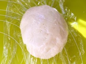 混合水油皮材料，活成面团，将面团倒在揉面垫上，一直揉至面团光滑，盖保鲜膜松弛