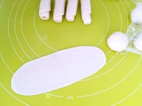 之后将面团擀成长条，从上往下卷起来，卷成牛舌卷状，之后盖保鲜膜松弛15分钟